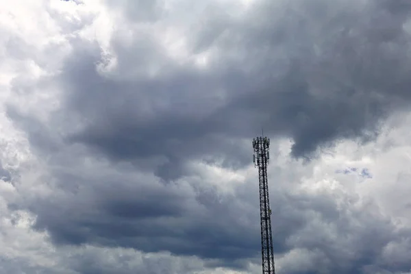 灰白色的浮云在天空中与电信塔 灰云天空背景下的塔信号 — 图库照片