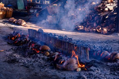 Geleneksel Khao Lam Nong Mon yemekleri Baan Nong Mon, Bang Saen, Tayland 'da hindistan cevizi kabuklarını yakıt olarak kullanır. Yanan Khao Lam, Tayland bambu tüpü tatlı kremalı pirinç tatlısı.