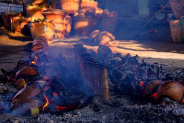 Geleneksel Khao Lam Nong Mon yemekleri Baan Nong Mon, Bang Saen, Tayland 'da hindistan cevizi kabuklarını yakıt olarak kullanır. Yanan Khao Lam, Tayland bambu tüpü tatlı kremalı pirinç tatlısı.