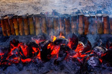 Geleneksel Khao Lam Nong Mon yemekleri Baan Nong Mon, Bang Saen, Tayland 'da hindistan cevizi kabuklarını yakıt olarak kullanır. Yanan Khao Lam, Tayland bambu tüpü tatlı kremalı pirinç tatlısı.