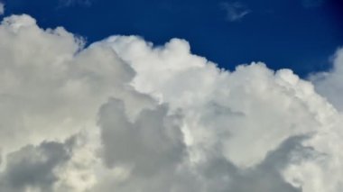 4K zaman atlaması, mavi gökyüzü arka planında güzel hareketli beyaz bulutlar. Kabarık beyaz bulutların mavi gökyüzünün zaman aşımına uğramış görüntüsü..