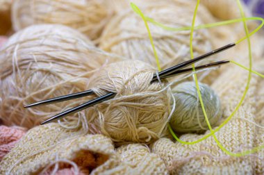 Örgü iğneleri, iplik izleri, örgü kumaşlar, ev işi. Yakın çekim, seçici odaklanma