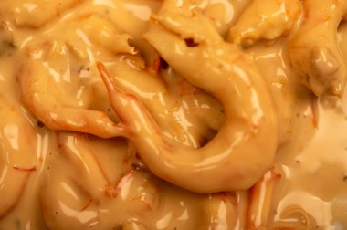 Baharatlı sosta soyulmuş ve haşlanmış karides. Yakın çekim, seçici odaklanma