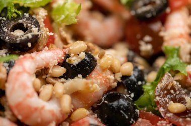 Tabakta karides ve çam fıstığı olan sebze salatası. Ev yapımı yemek. Kapat.