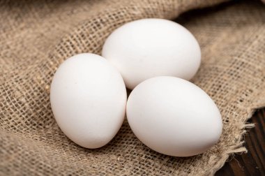 Kabataslak desenli ev yapımı kumaşın arka planında tavuk yumurtası. Yakın çekim, seçici odaklanma