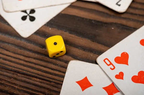 Playing cards and dice on a wooden table. Close-up, selective focus.