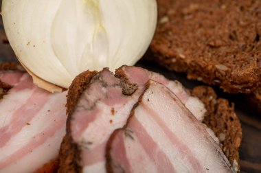 Tahta bir kesme tahtasındaki tahıllı ekmeğin üzerinde füme göğüs eti dilimlenmiş sandviç. Yakın çekim, seçici odaklanma.