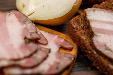 Tahta bir kesme tahtasındaki tahıllı ekmeğin üzerinde füme göğüs eti dilimlenmiş sandviç. Yakın çekim, seçici odaklanma.