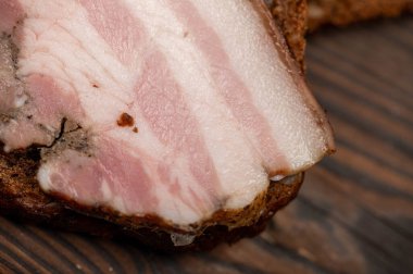 Tahta bir kesme tahtasındaki tahıllı ekmeğin üzerinde füme göğüs eti dilimlenmiş sandviç. Yakın çekim, seçici odaklanma.