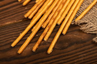 Kaba ev yapımı kumaşın üzerine serpiştirilmiş tuzlu ekmek şeritleri. Yakın çekim, seçici odaklanma.