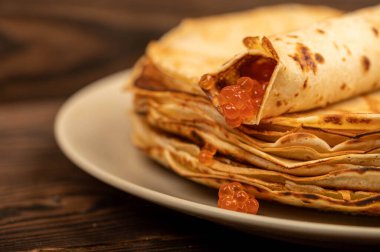 Geleneksel Rus gözlemeleri ve kırmızı somon havyarı. Bahar ayının Shrovetide haftası. Kışın gidişini görmek. Yakın çekim, seçici odaklanma.
