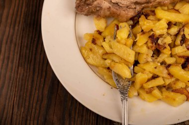 Ev yapımı kızarmış patates ve beyaz tabakta büyük bir parça et. Yakın plan..