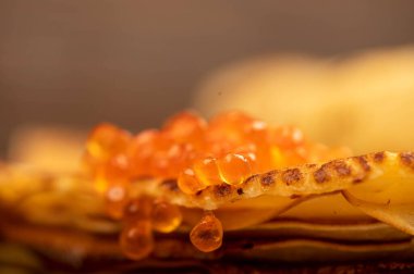 Geleneksel Rus gözlemeleri ve kırmızı somon havyarı. Bahar ayının Shrovetide haftası. Kışın gidişini görmek. Yakın çekim, seçici odaklanma.