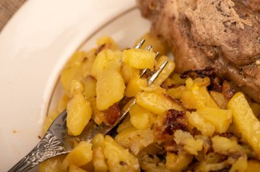 Ev yapımı kızarmış patates ve beyaz tabakta büyük bir parça et. Yakın plan..