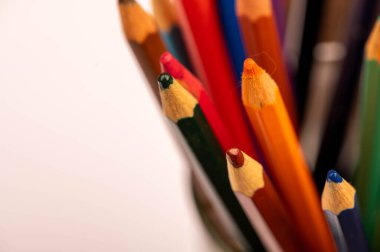 Ahşap bir masada renkli kalemler ve beyaz kağıtlar. Seçici odaklanmayı kapat.