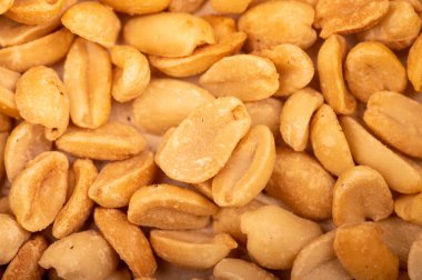 Kızarmış tuzlu fıstık, yüzey dokusu. Yakın plan, seçici odaklanma. Bira için favori atıştırmalık..