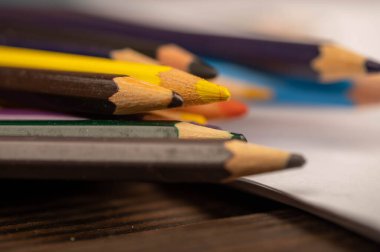 Tahta masadaki renkli kalemler. Yakın plan, seçici odaklanma. Covid-19 salgınında kendini soyutlama sırasında kendini geliştirme.