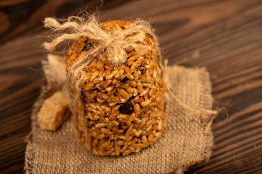 Ayçiçeği tohumlu ev yapımı kurabiyeler ve iplikle bağlanmış kuru üzümler ve tahta bir masanın üzerinde kahverengi kamış şekeri parçaları. Seçici Odaklamayı Kapat