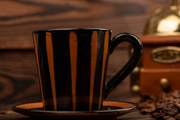 Auf Einer Holzoberfläche Verstreute Geröstete Kaffeebohnen Eine Kaffeetasse Mit Untertasse — Stockfoto