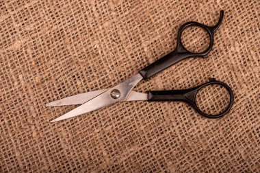 Kabataslak desenli ev yapımı kumaş parçasında küçük bir makas.