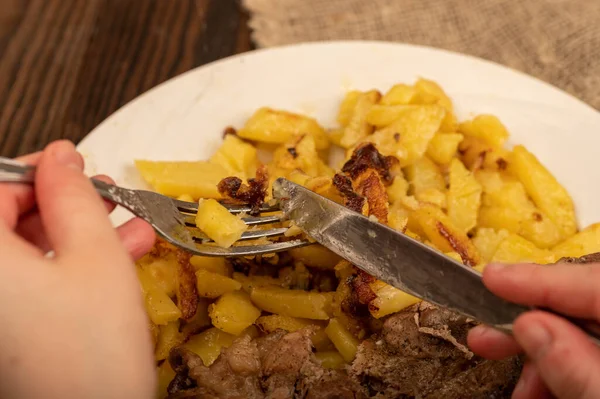 Someone Cutting Piece Juicy Roast Meat Plate Fried Potatoes Knife — Stock Photo, Image