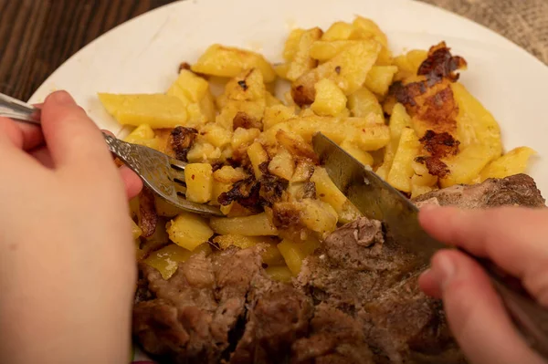 Someone Cutting Piece Juicy Roast Meat Plate Fried Potatoes Knife — Stock Photo, Image