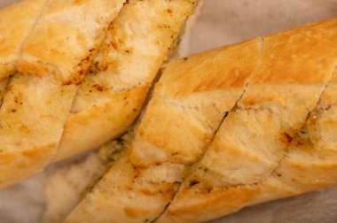 Sarımsak ezmeli baget. Parça parça kesilmiş, yakın plan, seçici odaklı.