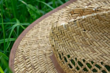 Yeşil çimlerin üzerinde eski bir hasır şapka, yakın plan, seçici odaklanma