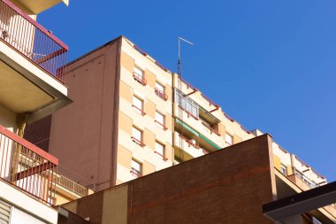 Mavi gökyüzünün arka planına karşı binaların köşeleri; basit işçi sınıfı komşu binaların köşeleri tarafından oluşturulan açılar. Terası olmayan binaların pencereleri.