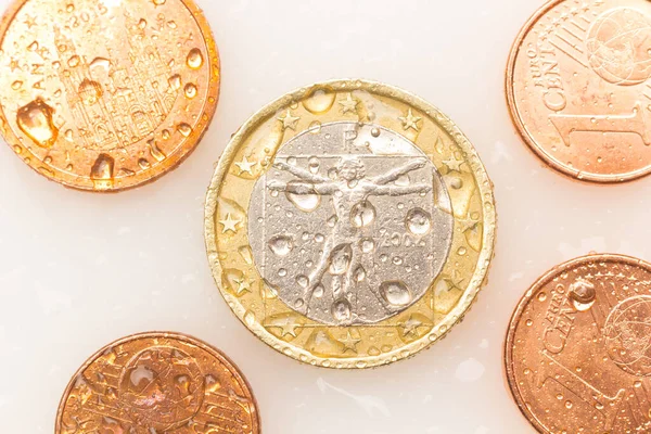 Euro coins, euros and euro cents on white background. Coins with water drops.