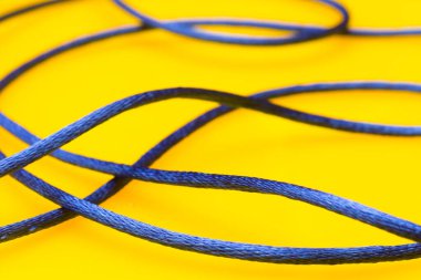Sarı arkaplanda ince mavi iplik, düzensiz makarada dağınık iplik, karışık iplik.