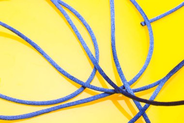 Sarı arkaplanda ince mavi iplik, düzensiz makarada dağınık iplik, karışık iplik.