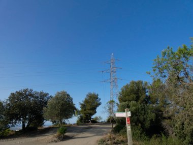 Elektrik enerjisi taşıyan bakır kabloları destekleyen metal kuleler, mavi gökyüzündeki kuleler: Yüksek voltaj kuleleri, elektrik kablolarını desteklemek için mühendislik çalışmaları