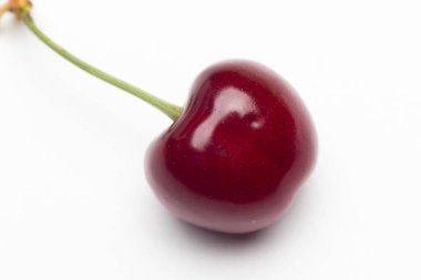 Vitamin ve lezzetli tatlarla dolu beyaz bir zemin üzerinde küçük kırmızı kiraz seti, çiğ ya da tatlı yemek için ideal..
