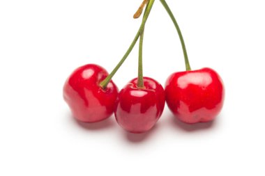 Vitamin ve lezzetli tatlarla dolu beyaz bir zemin üzerinde küçük kırmızı kiraz seti, çiğ ya da tatlı yemek için ideal..