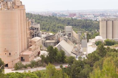 Birkaç yıl önce kapatılmış çimento fabrikası, siloları ve fırınları bomboş duruyor. Barselona yakınlarındaki dağlarda çimento fabrikası..