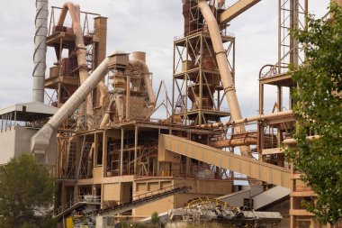 Birkaç yıl önce kapatılmış çimento fabrikası, siloları ve fırınları bomboş duruyor. Barselona yakınlarındaki dağlarda çimento fabrikası..