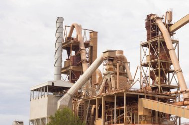 Birkaç yıl önce kapatılmış çimento fabrikası, siloları ve fırınları bomboş duruyor. Barselona yakınlarındaki dağlarda çimento fabrikası..