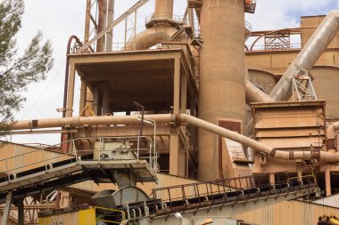 Birkaç yıl önce kapatılmış çimento fabrikası, siloları ve fırınları bomboş duruyor. Barselona yakınlarındaki dağlarda çimento fabrikası..