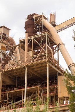 Birkaç yıl önce kapatılmış çimento fabrikası, siloları ve fırınları bomboş duruyor. Barselona yakınlarındaki dağlarda çimento fabrikası..