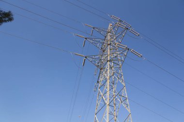 Dağlarda bir elektrik kulesi, dağlık araziyi aşarak sanayiye ve evlerimize elektrik getiriyor. Yeşil enerji
