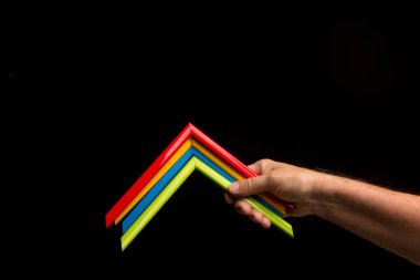 Eldeki farklı renkler kamerayı gösteriyor. Basit ve birincil renkler, siyah arkaplanda parlak renkler..