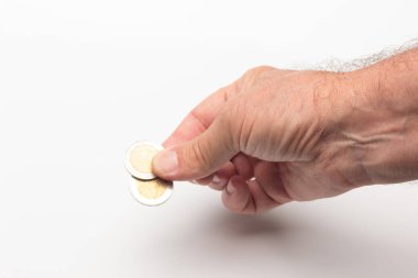 Küçük ödemeler yapmak ya da zuladan tasarruf etmek için bozukluklar. Avro sikkeleri yetişkin birinin elinde, beyaz arka planda..