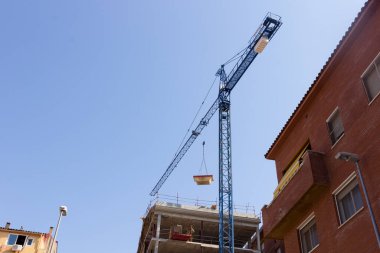 Crane inşaat alanında çalışıyor. Malzemeleri taşıyor ve topluyor.. 