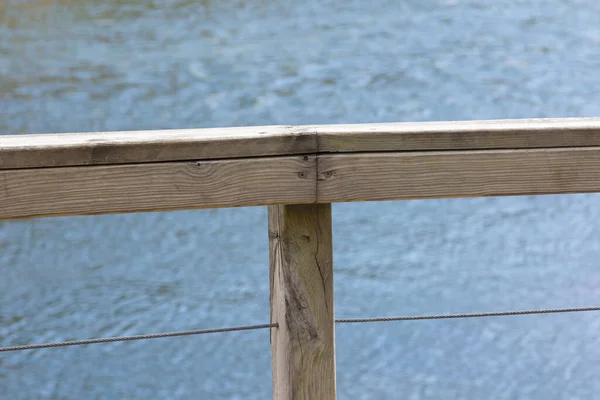 Light-colored weathered wood railing on blue background