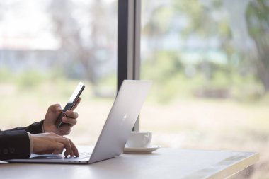 Beyaz kahve fincanı ve iş adamı laptopu bulanık arka plan olarak yazıyorlar