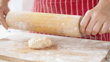 Kırmızı önlüklü bir kadın tarafından yapılan ev yapımı tahıl hamurundan tam buğday ekmeği. Bol taneli sağlıklı hamur işi..