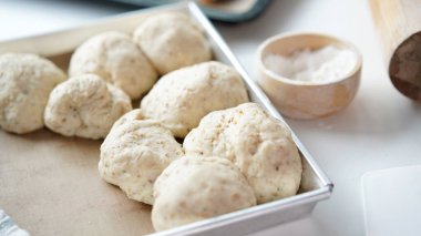 Kırmızı önlüklü bir kadın tarafından yapılan ev yapımı tahıl hamurundan tam buğday ekmeği. Bol taneli sağlıklı hamur işi..