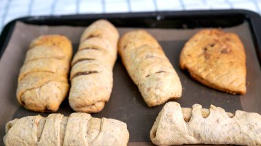 Kırmızı önlüklü bir kadın tarafından yapılan ev yapımı tahıl hamurundan tam buğday ekmeği. Bol taneli sağlıklı hamur işi..