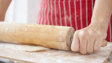 Kırmızı önlüklü bir kadın tarafından yapılan ev yapımı tahıl hamurundan tam buğday ekmeği. Bol taneli sağlıklı hamur işi..